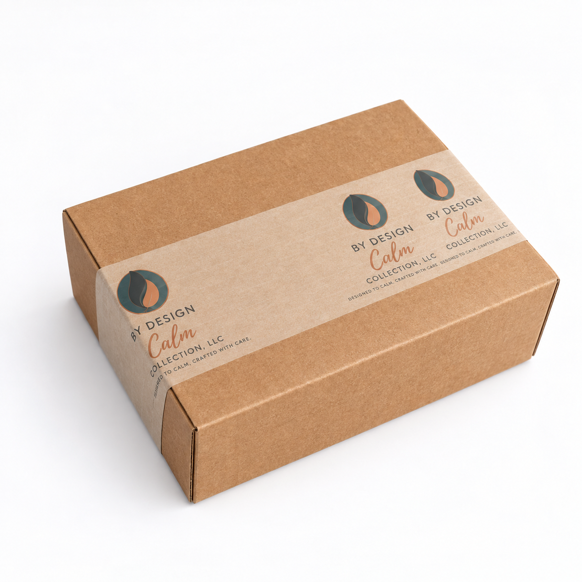 Closed kraft By Design Calm Collection gift box with branded packaging, containing the candle and Calm Journal set.