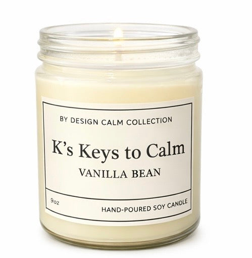 Candle in a glass jar labeled 'K's Keys to Calm Vanilla Bean' on a white background